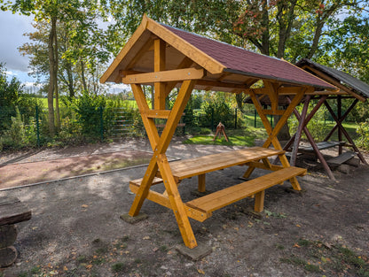 Waldschänke Premium XXL mit rotem Biberschwanz-Dach auf einem Spielplatz – Seitenansicht